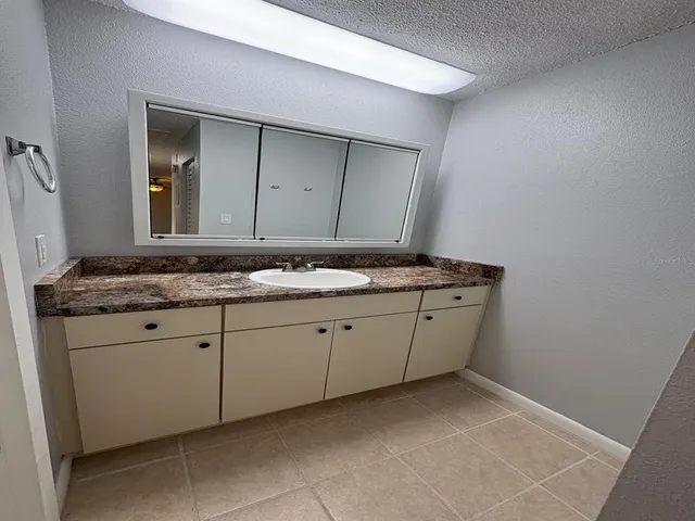 a bathroom with a granite countertop sink and mirror