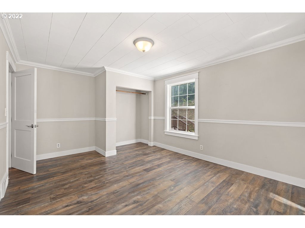 91158 Youngs River Road Astoria, OR 97103 - Photo 16 of 32 a view of an empty room with wooden floor and a window