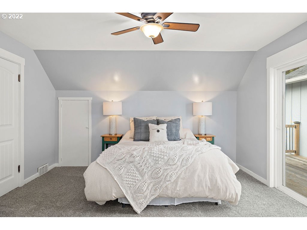 91158 Youngs River Road Astoria, OR 97103 - Photo 21 of 32 a bedroom with a bed and a chandelier