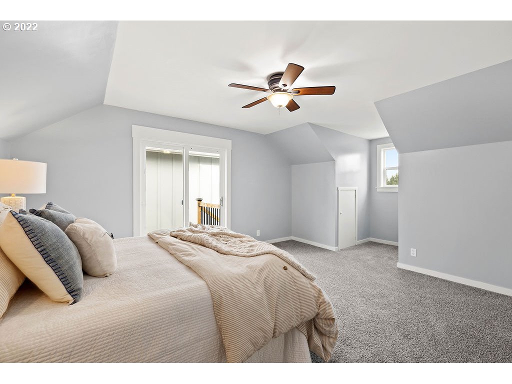 91158 Youngs River Road Astoria, OR 97103 - Photo 22 of 32 a bedroom with a bed and a chandelier