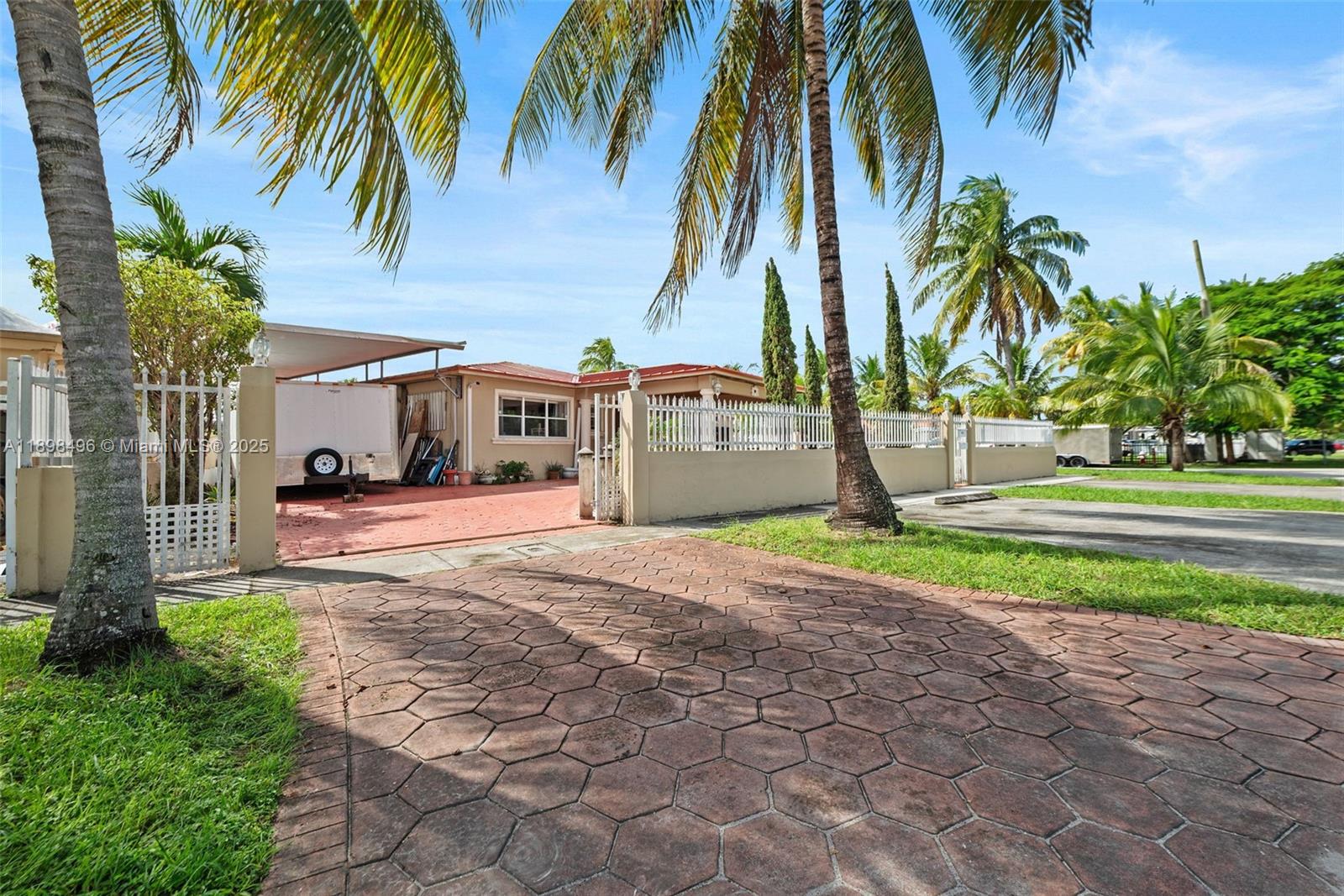 a view of a house with a yard and palm trees