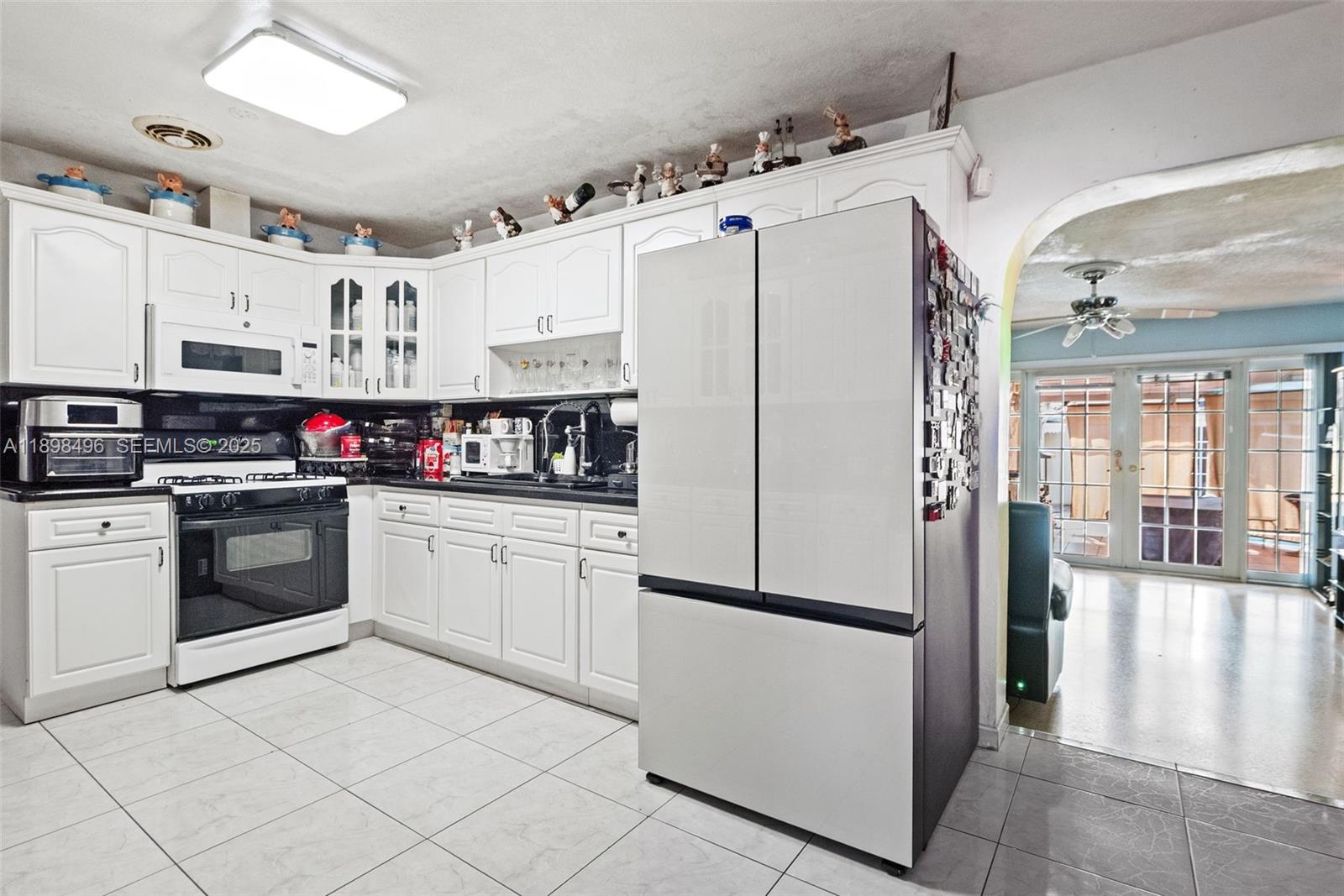 100 East 37th Street Hialeah, FL 33013 - Photo 11 of 25 a kitchen with stainless steel appliances a refrigerator sink and cabinets