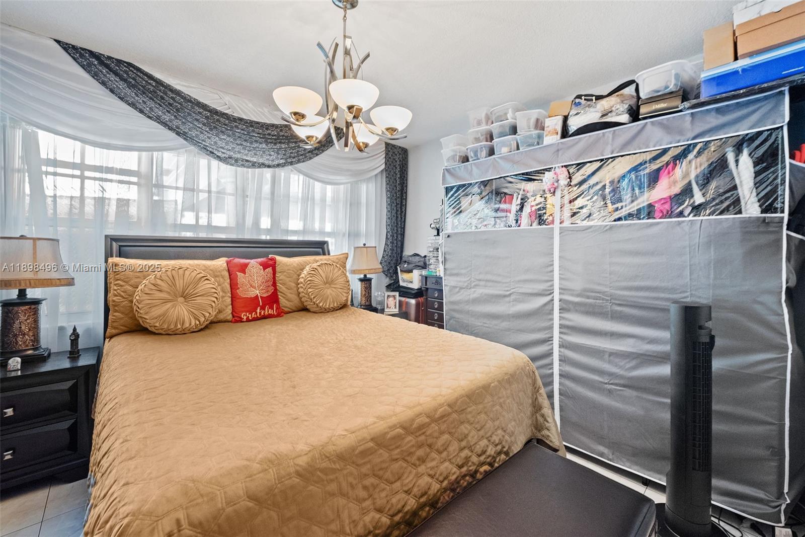 100 East 37th Street Hialeah, FL 33013 - Photo 13 of 25 a bedroom with a bed and a chandelier