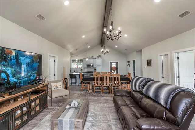 a living room with furniture a flat screen tv and kitchen view