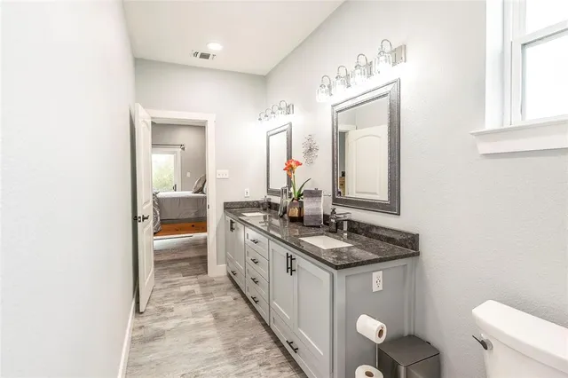 a en suite bathroom with a granite countertop sink and a mirror