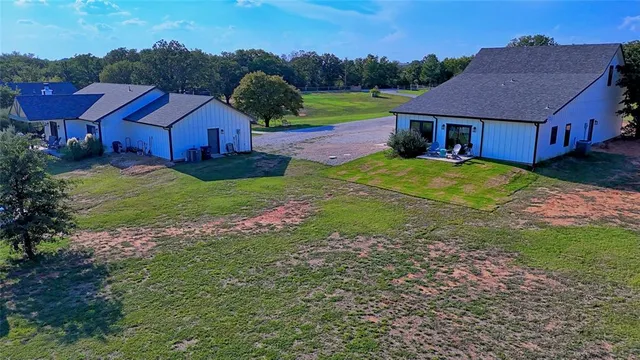 a aerial view of a house with table and chairs under an umbrella