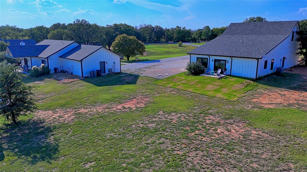 140 Lago Lane Nocona, TX 76255 - Photo 2 of 39 a aerial view of a house with table and chairs under an umbrella