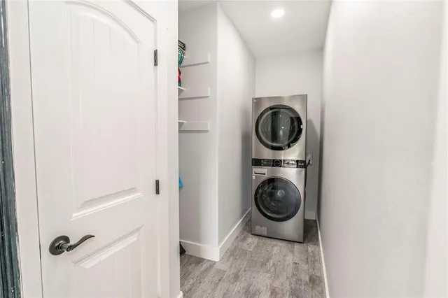 a kitchen with kitchen island a sink stove a refrigerator and white cabinets with wooden floor