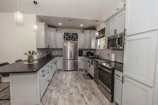 a kitchen with kitchen island granite countertop a sink stainless steel appliances and counter space