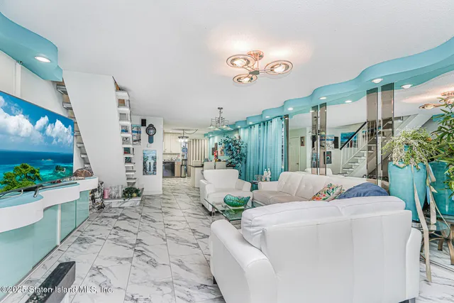 a living room with furniture flowerpot and a chandelier