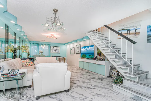 a living room with furniture and a chandelier