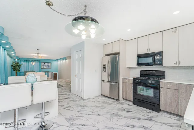 a kitchen with stainless steel appliances granite countertop a refrigerator and a stove top oven