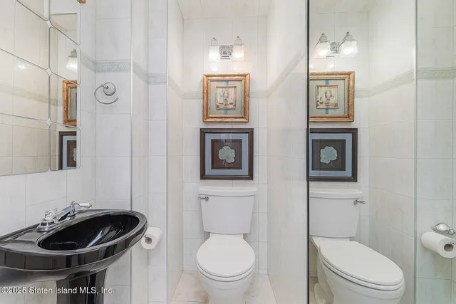 a bathroom with a toilet a sink and a mirror