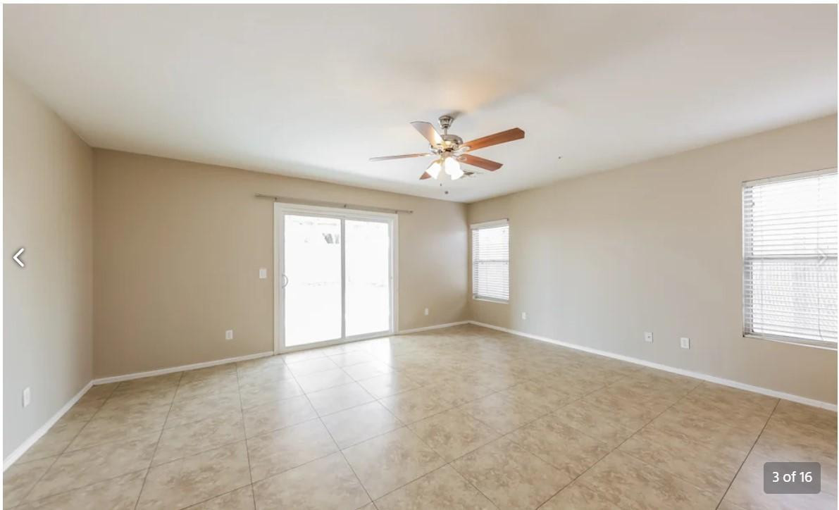 12563 West Charter Oak Road El Mirage, AZ 85335 - Photo 3 of 16 an empty room with windows and chandelier fan