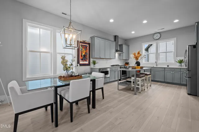a view of a dining room and livingroom with furniture wooden floor a chandelier