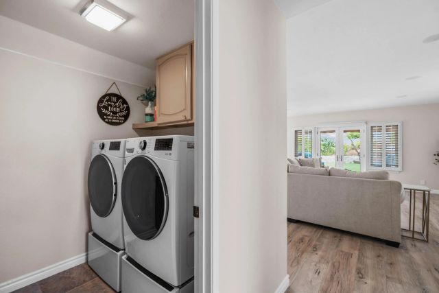 a utility room with wooden floor washer and dryer