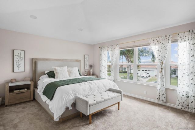 a bedroom with a bed lamp and a large window