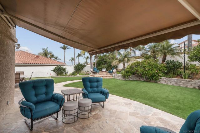 a view of a patio with couches chairs potted plants and a big yard