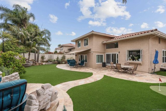 a view of a house with backyard sitting area and garden