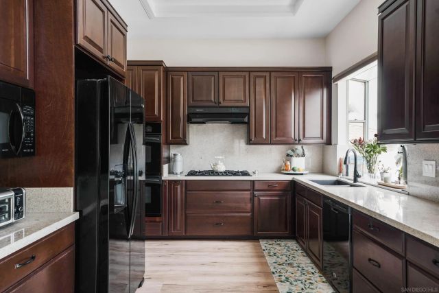 a kitchen with kitchen island granite countertop a sink stove and refrigerator