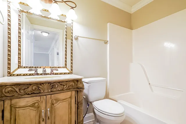 a bathroom with a sink a toilet a mirror and shower