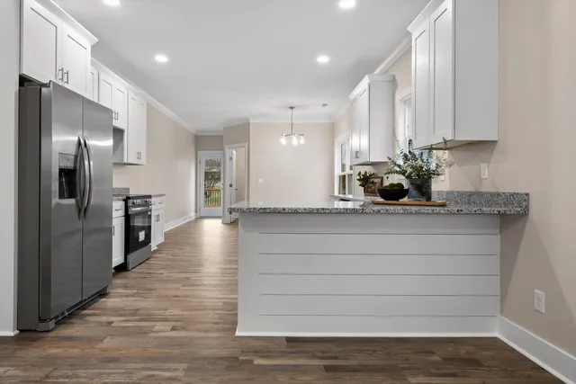 a kitchen with granite countertop white cabinets and white appliances