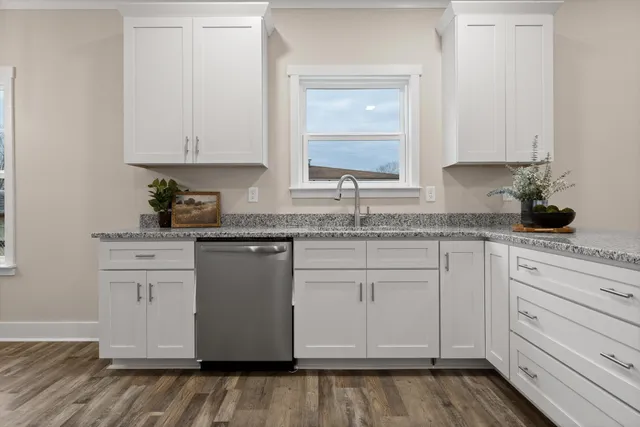a kitchen with granite countertop white cabinets and white appliances