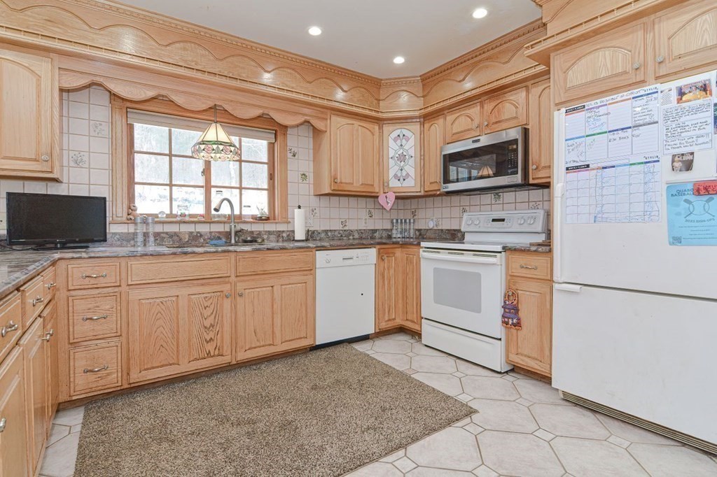 101 Dunham Road Warren, MA 01010 - Photo 5 of 21 a kitchen with granite countertop white cabinets sink and white appliances