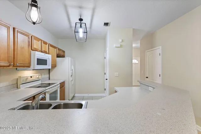 a kitchen with stainless steel appliances a refrigerator and a stove top oven