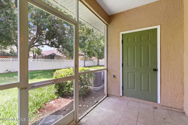 a view of a room with a large window and front door