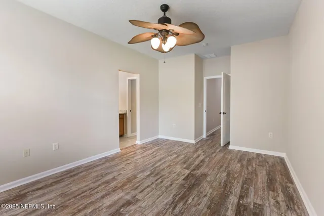 a view of an empty room with wooden floor