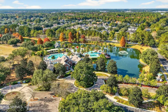 an aerial view of residential houses with outdoor space and trees