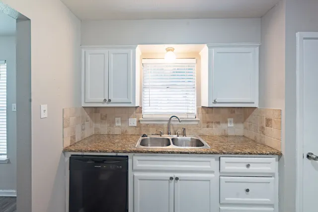 an empty room with a window and a ceiling fan