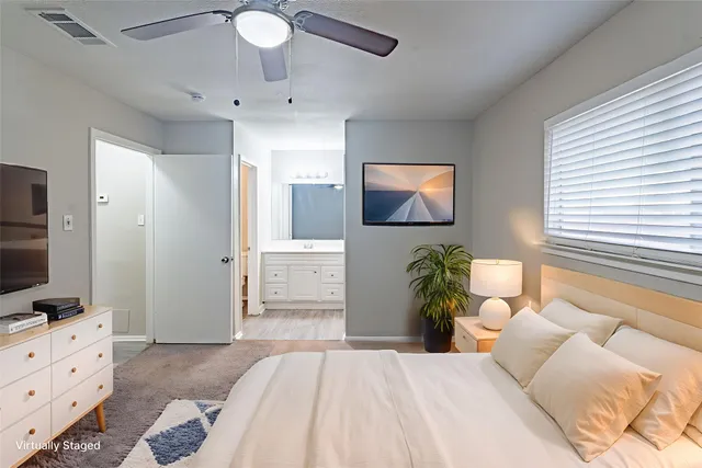 a bedroom with a bed and a flat tv screen on dresser