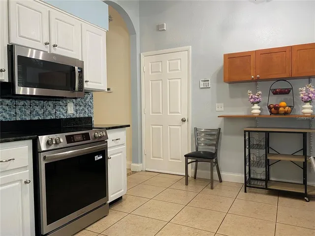 a kitchen with granite countertop a stove top oven and cabinets