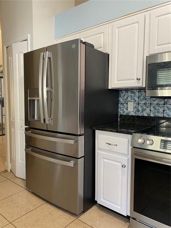 1020 Vernon Loop Oviedo, FL 32765 - Photo 14 of 34 a kitchen with stainless steel appliances white cabinets white stove a refrigerator and a microwave