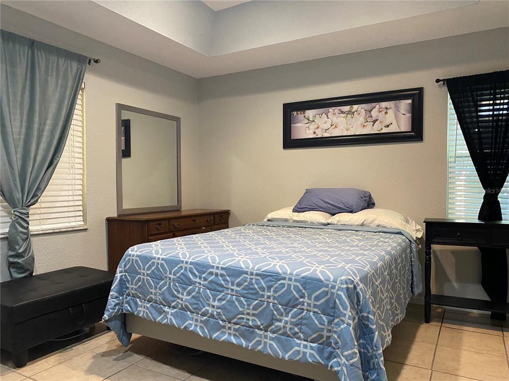 1020 Vernon Loop Oviedo, FL 32765 - Photo 16 of 34 a bedroom with a bed and a chandelier