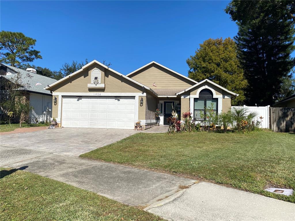 1020 Vernon Loop Oviedo, FL 32765 - Photo 2 of 34 a front view of a house with a garden and yard