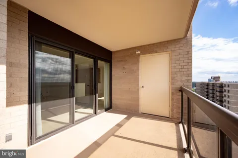 a view of balcony with a couple of cars parked in front of it