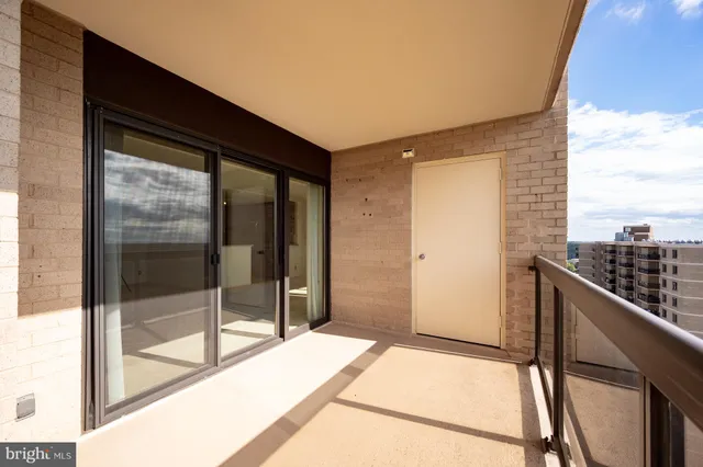 a view of balcony with a couple of cars parked in front of it