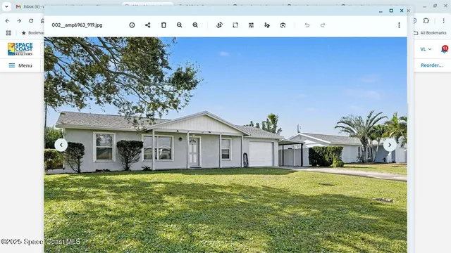 a front view of a house with a garden and tree