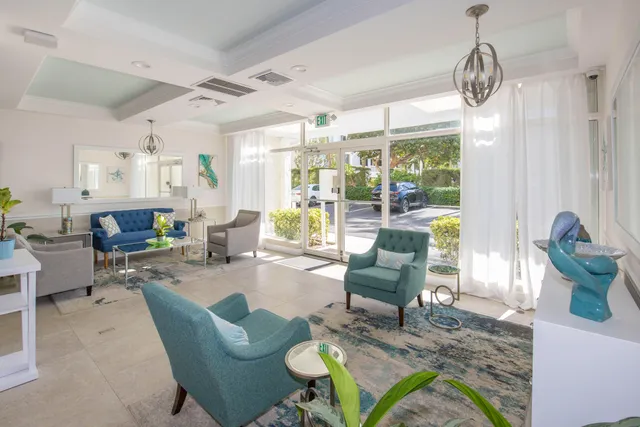 a living room with furniture a chandelier and a dining table