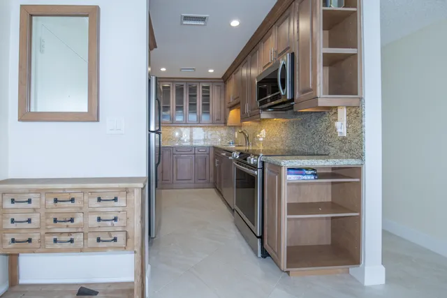 a kitchen with stainless steel appliances granite countertop a stove and a microwave