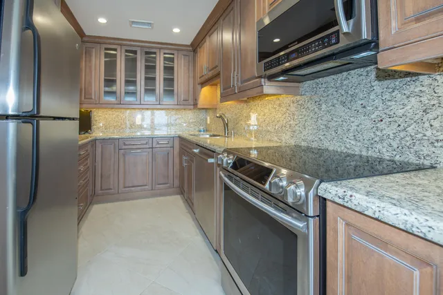 a kitchen with granite countertop sink and cabinets
