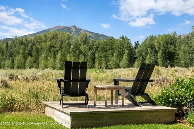 a view of a swimming pool with a bench and some trees