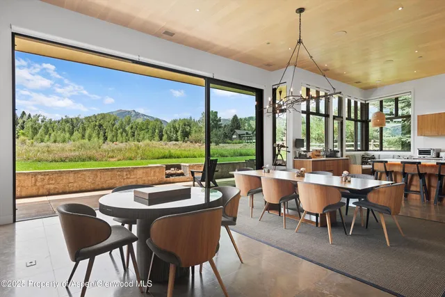 a dining room with furniture a chandelier and garden view
