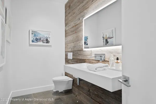 a bathroom with a sink a toilet and mirror