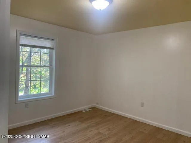 an empty room with wooden floor and closet