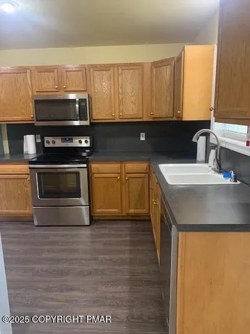a kitchen with stainless steel appliances a stove a sink and a microwave