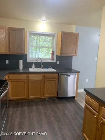 a kitchen with stainless steel appliances a sink a counter top space and cabinets